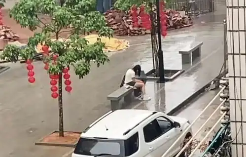 广东一女子失恋太伤心,独自坐在街头淋雨,男子好心送伞也不理会
