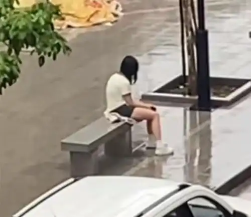 广东一女子失恋太伤心,独自坐在街头淋雨,男子好心送伞也不理会
